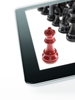 Studio shot of red chess queen and black chess pawns on tablet. Photo : David Arky