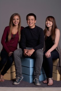 Portrait of teenage boy (16-17) and girl (16-17) with young friend, studio shot. Photo : Rob Lewine