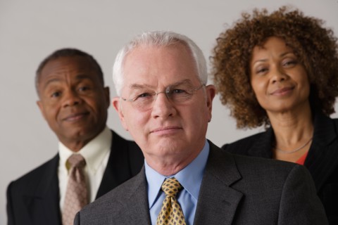 Portrait of three business people, studio shot. Photo : Rob Lewine