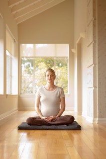 Pregnant woman practicing yoga. Photo : Rob Lewine