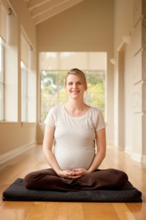 Pregnant woman practicing yoga. Photo : Rob Lewine