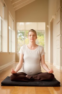 Pregnant woman practicing yoga. Photo : Rob Lewine