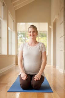 Pregnant woman practicing yoga. Photo : Rob Lewine