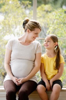 Daughter (6-7) sitting next to pregnant mother. Photo : Rob Lewine
