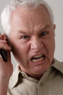 Portrait of angry senior man with mobile phone, studio shot. Photo : Rob Lewine