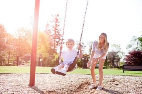 USA, Washington State, Seattle, Mother and son (2-3) swinging on swing in park. Photo: Take A Pix