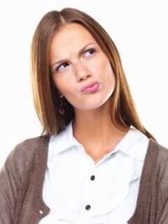 Close-up of business woman in doubt pursing her lips and looking away. Photo : momentimages