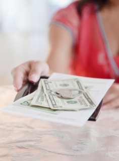 Woman taking money. Photo : Jamie Grill