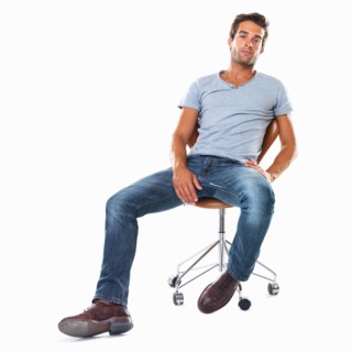 Studio shot of handsome young man sitting comfortably on chair. Photo : momentimages