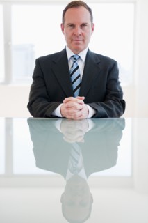 Businessman sitting at table. Photo : Jamie Grill