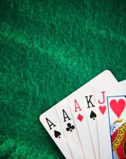 Close up of hand of cards on green felt. Photo : Jamie Grill