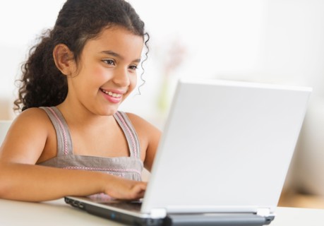 Girl (8-9) using laptop.