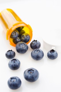 Blueberries spilling from prescription bottle.