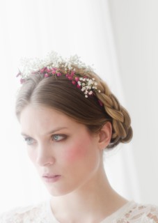 Pensive young woman with flowers in hair.