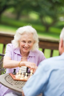 Seniors playing chess on porch.