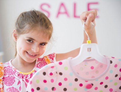 Girl ( 6-7) showing clothes while shopping. Photo : Jamie Grill