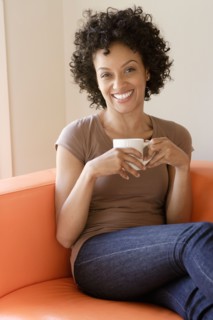 Portrait of young woman sitting on sofa. Photo : Rob Lewine
