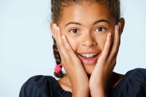 Studio portrait of girl (10-11) with head in hands. Photo : Rob Lewine
