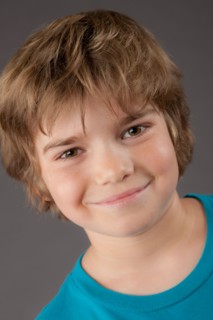 Portrait of smiling boy (8-9), studio shot. Photo: Rob Lewine