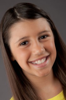 Portrait of smiling girl (8-9), studio shot. Photo : Rob Lewine