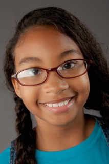 Studio portrait of girl (8-9) wearing eyeglasses. Photo: Rob Lewine