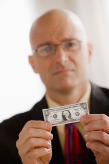 Portrait of business man holding one dollar bill. Photo : Rob Lewine
