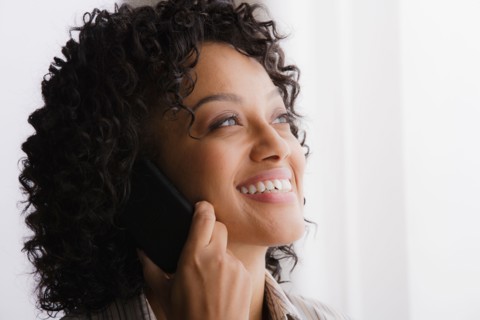 Portrait of smiling businesswoman on phone. Photo : Rob Lewine