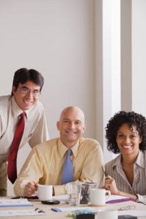 Portrait of smiling business people at meeting. Photo : Rob Lewine