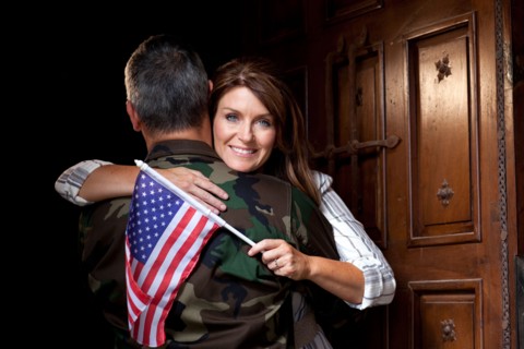 Soldier with wife embracing. Photo : db2stock