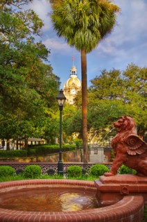 USA, Georgia, Savannah, Fountain in park with dome of City Hall in background.