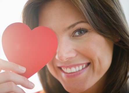 Close up of woman holding red paper heart. Photo : Jamie Grill