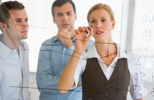 Businesswoman writing on transparent board.