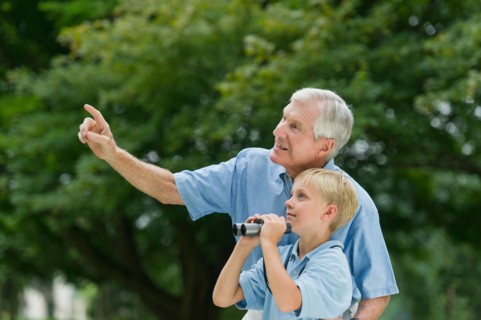 Grandfather and grandson (10-11) in park.