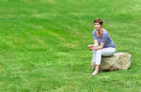 Mature woman sitting on rock.
