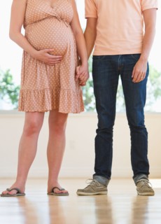 Pregnant woman holding partner's hand.