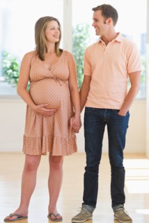 Pregnant woman holding partner's hand.