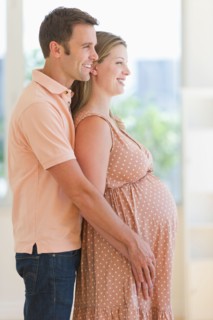 Pregnant woman and her partner standing together.
