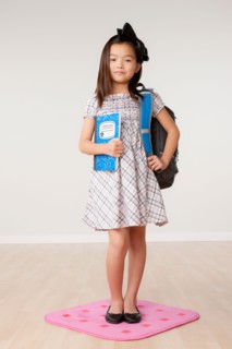 Studio portrait of girl (8-9) carrying backpack. Photo : Rob Lewine
