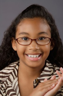 Portrait of smiling girl (8-9), studio shot. Photo : Rob Lewine