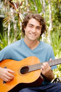 Portrait of young man playing guitar. Photo : Rob Lewine