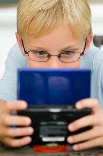 Boy (10-11) playing video game.