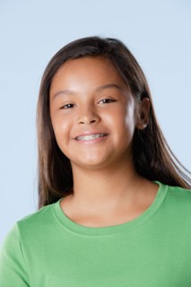Studio portrait of girl smiling (10-11). Photo : Rob Lewine