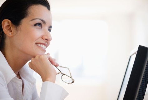 Businesswoman daydreaming at desk in office. Photo : Jamie Grill