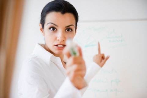 Businesswoman pointing during business meeting. Photo: Jamie Grill