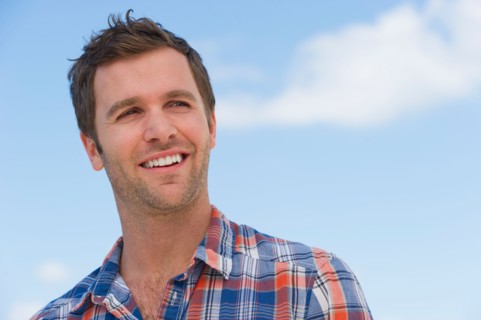 Portrait of mid adult man against blue sky.