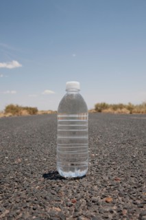 Water bottle sitting in middle of desert road. Photo : Winslow Productions