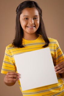 Studio portrait of girl (10-11) holding blank sheet of paper. Photo : Rob Lewine