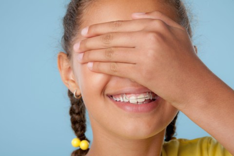 Studio shot of girl (10-11) covering eyes with hand. Photo : Rob Lewine
