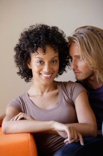 Portrait of young couple sitting in armchair. Photo: Rob Lewine