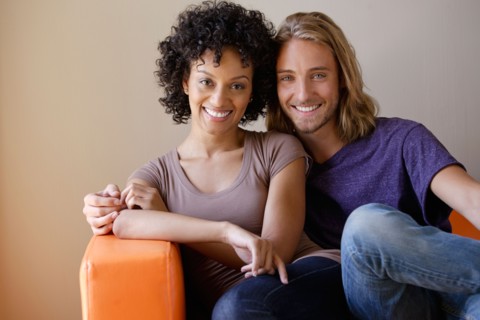 Portrait of young couple sitting in armchair. Photo : Rob Lewine